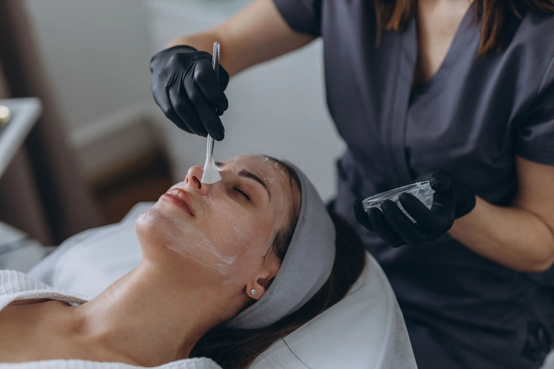 A woman is getting a facial treatment at a beauty salon.